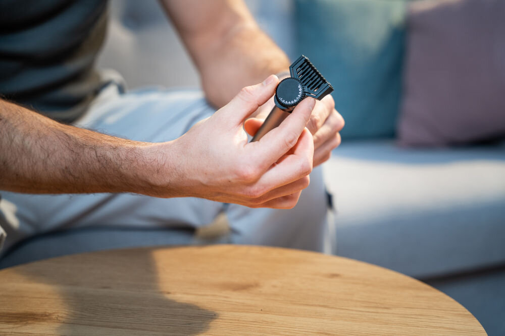 Trymer GÖTZE & JENSEN TR751 bez kabli akumulator osoba trzymajaca trymer w ręce regulująca długość pokrętłem