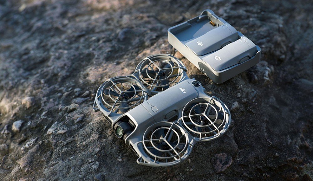 Dron DJI Neo 2 Fly More Combo Zestaw akcesoriów z kontrolerem, dwiema bateriami, ładowarką, przewodami i małym dronem ułożony na jasnym blacie, zestaw, akcesoria