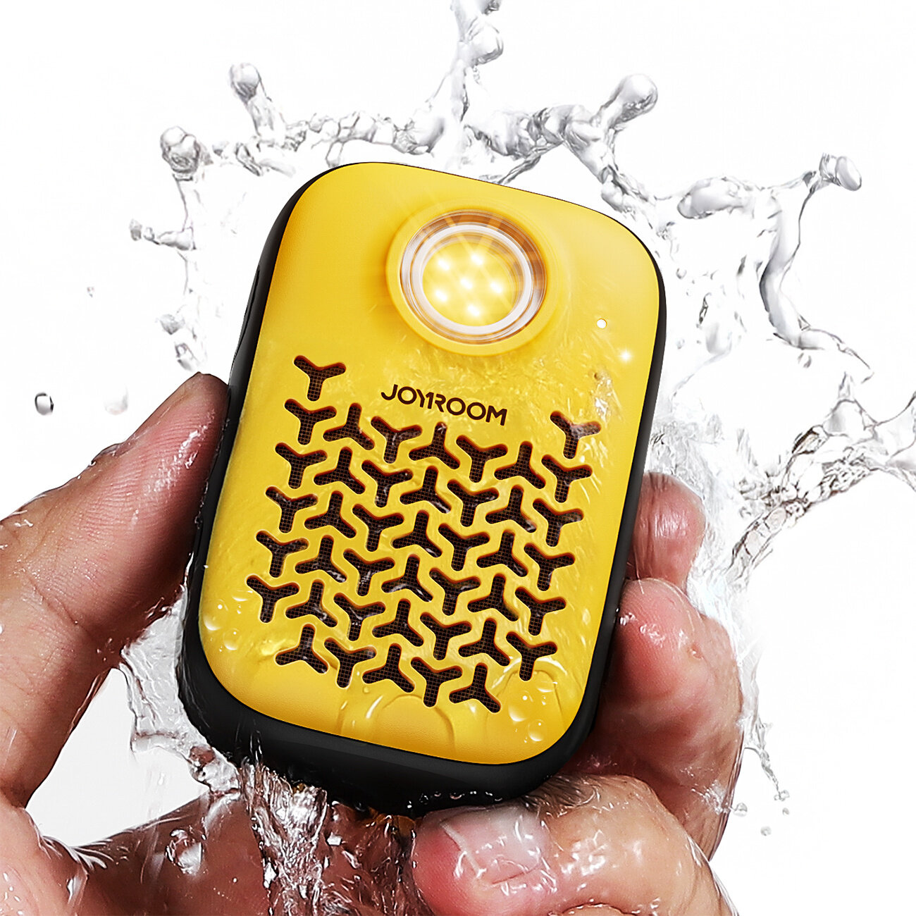 Żółty głośnik Bluetooth z wbudowaną latarką, trzymany w dłoni, jest spryskiwany wodą. Na obudowie widoczne jest logo \'JOYROOM\'.