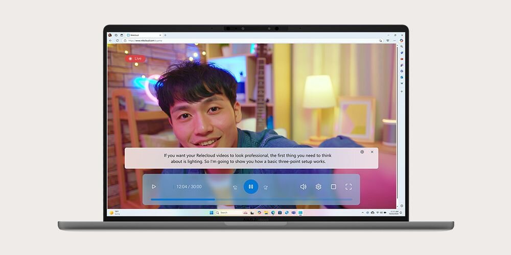 Laptop ASUS ZenBook wyświetlający funkcję napisów na żywo podczas transmisji wideo z młodym mężczyzną w kolorowym tle, z odtwarzaczem wideo i panelem napisów na ekranie - tłumaczenie mowy w czasie rzeczywistym   