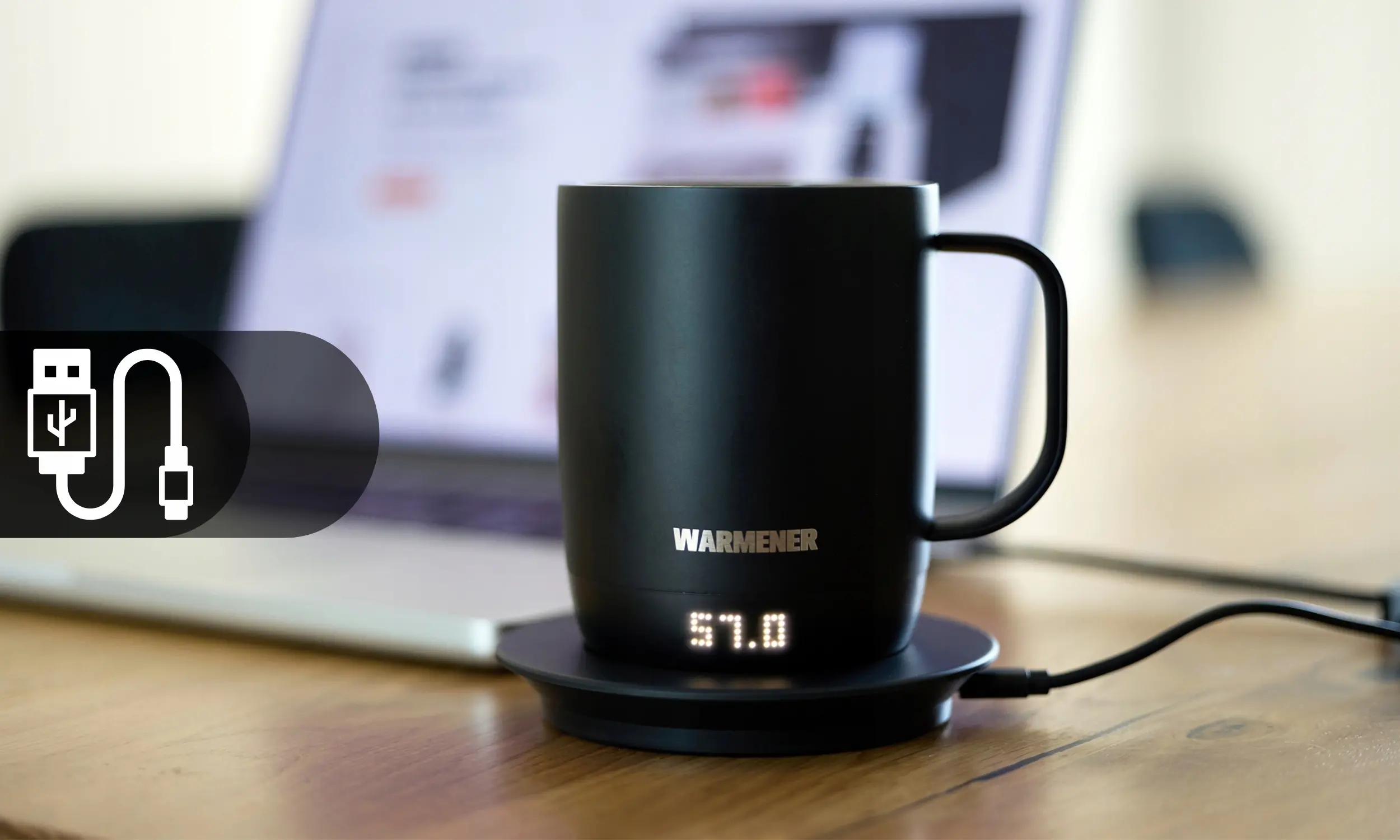 Kubek Warmener trzymany w dłoni podczas pracy przy biurku