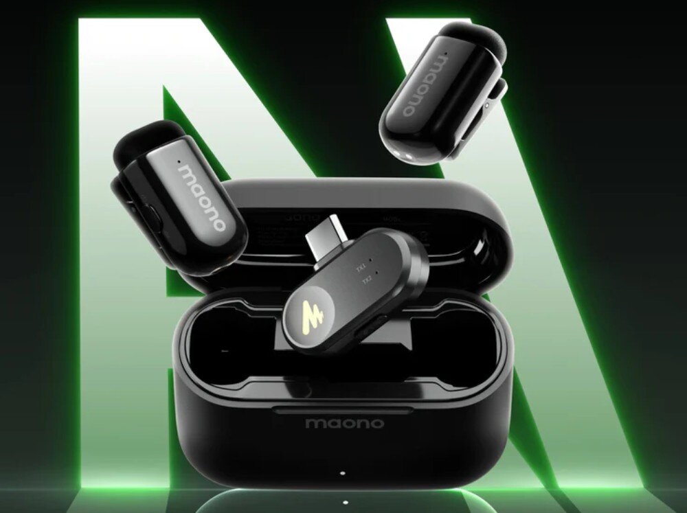 System bezprzewodowy MAONO WM622 PC2 otwarte czarne etui ładujące z napisem maono, wewnątrz którego znajduje się odbiornik ze złączem USB typu C, a powyżej lewitują dwa małe bezprzewodowe mikrofony na tle dużej litery M podświetlonej na zielono
