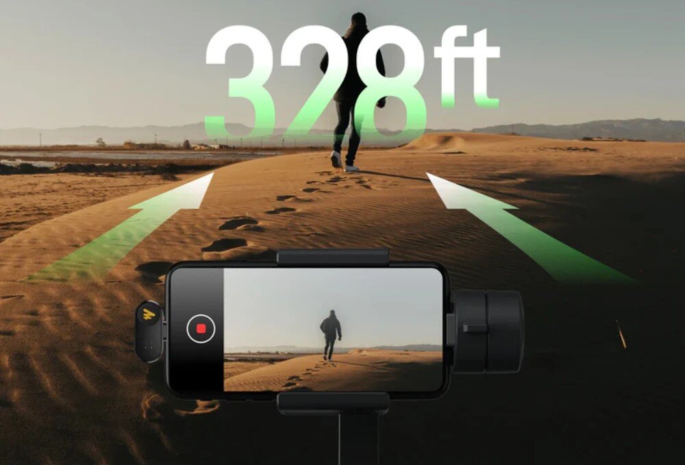 System bezprzewodowy MAONO WM622 PC2 widok na ekran smartfona rejestrującego postać idącą przez piaszczyste wydmy, nad którą widnieje duży biały napis 328ft z zielonym przejściem tonalnym, a do telefonu wpięty jest niewielki odbiornik