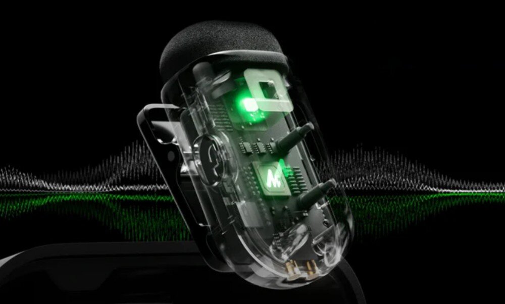 System bezprzewodowy MAONO WM622 PC2 przekrój technologiczny mikrofonu pokazujący wewnętrzne układy scalone, procesor z logo marki oraz inne komponenty elektroniczne podświetlone na zielono, z falą dźwiękową w tle