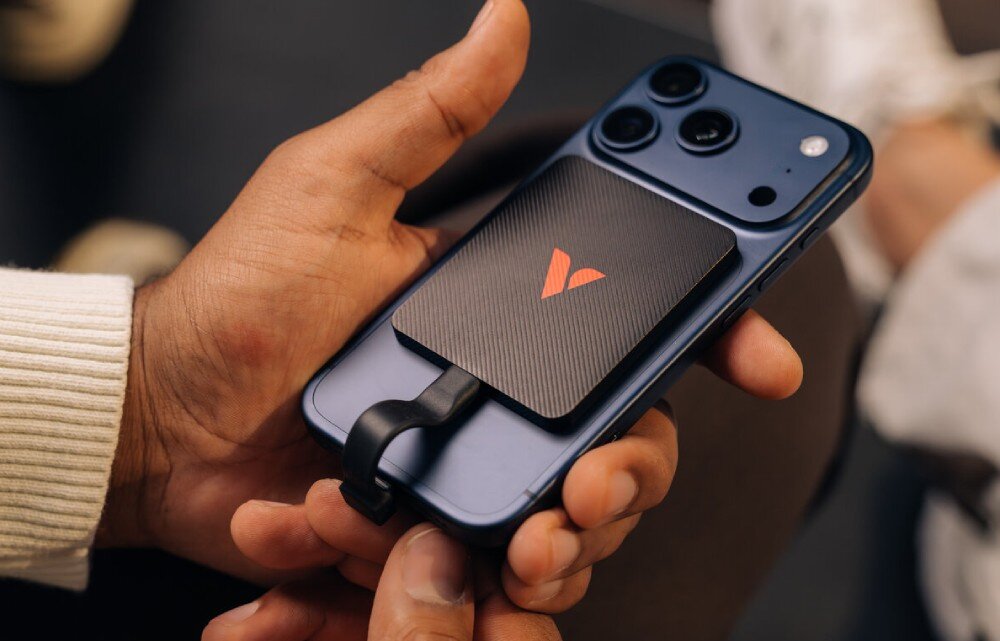 Dysk VERBATIM SnapBack Ultra Slim Zbliżenie na dłoń trzymającą niebieski telefon z przymocowanym magnetycznie teksturowanym dyskiem, który łączy się z gniazdem urządzenia za pomocą krótkiego, płaskiego przewodu, obudowa, wykonanie, materiały, kompatybilność