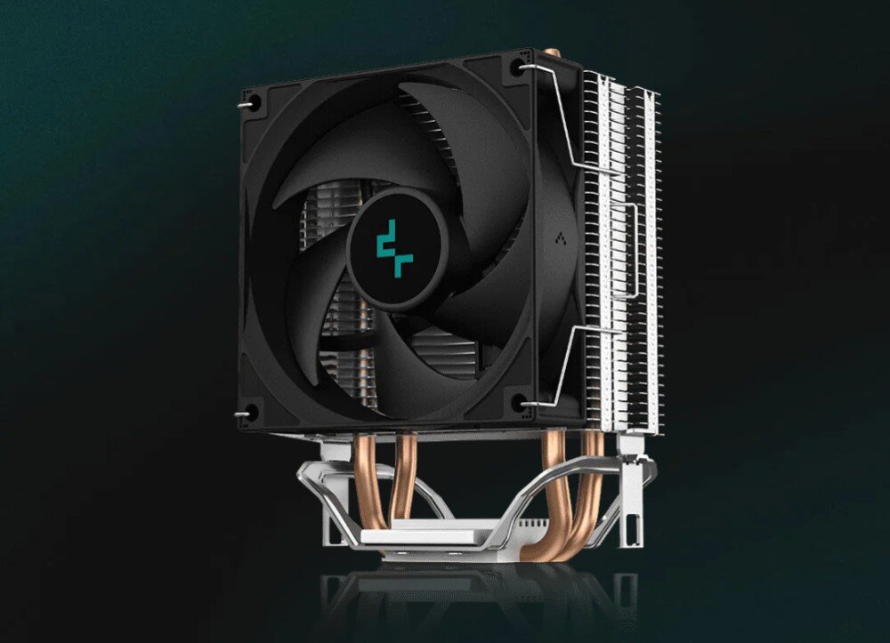 Komputer XQUANTUM XQI5R16S1TB-XI23WP Pionowo ustawiony radiator procesora z pojedynczym czarnym wentylatorem z logo producenta na środku, miedzianymi ciepłowodami u dołu oraz srebrnym mocowaniem na ciemnym tle