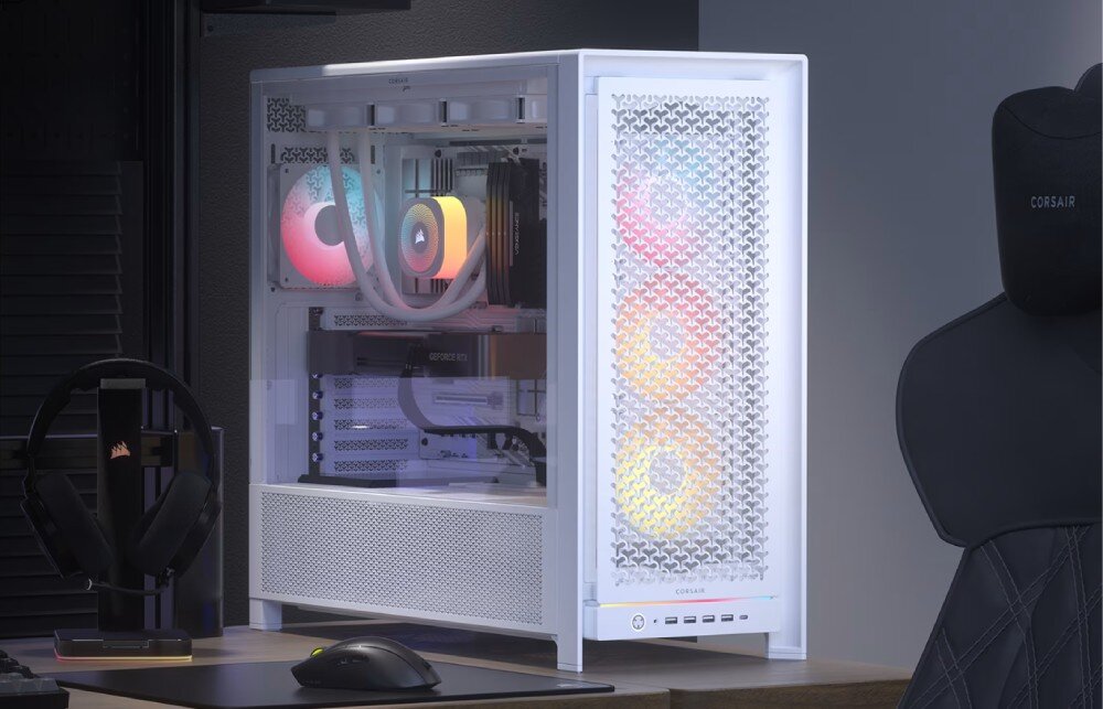 Obudowa CORSAIR Frame 5000D RS ARGB Komputer stacjonarny w obudowie z przeszklonym bokiem stoi na biurku obok myszki i słuchawek. Wnętrze rozświetlają kolorowe wentylatory oraz system chłodzenia cieczą z podświetlaną pompą
