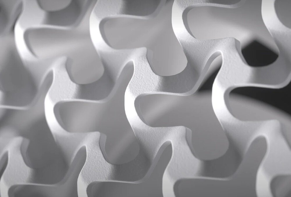 Obudowa CORSAIR Frame 5000D RS ARGB Duże zbliżenie na detale przedniego panelu obudowy. Metalowa powierzchnia ma gęstą strukturę wycięć w kształcie zazębiających się trójramiennych gwiazd o lekko chropowatej fakturze