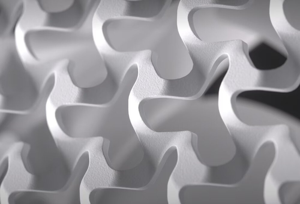 Obudowa CORSAIR Frame 5000D RS Bliskie ujęcie metalowej siatki o nieregularnym, powtarzalnym wzorze z zaokrąglonymi wycięciami