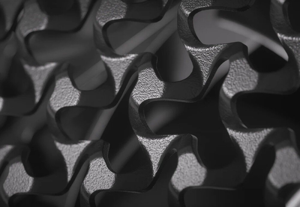 Obudowa CORSAIR Frame 5000D RS ARGB Duże zbliżenie na detale przedniego panelu obudowy. Metalowa powierzchnia ma gęstą strukturę wycięć w kształcie zazębiających się trójramiennych gwiazd o lekko chropowatej fakturze