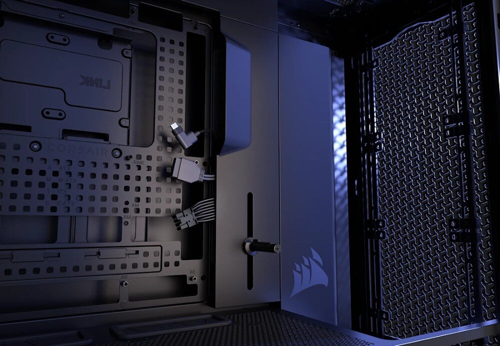 Obudowa CORSAIR Frame 5000D RS ARGB Wnętrze pustej czarnej obudowy widziane pod kątem od środka. Widoczne są otwory montażowe dla różnych formatów płyt głównych, pionowa maskownica kabli z logo oraz ażurowy panel przedni od strony wewnętrznej