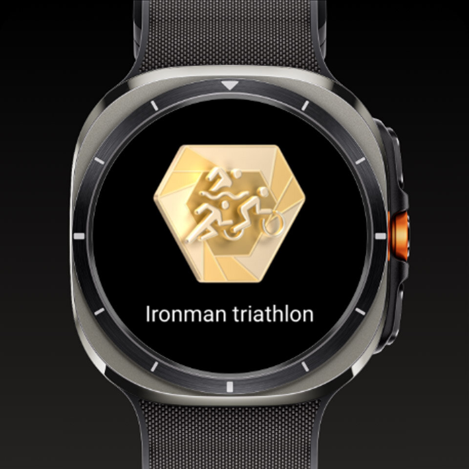 Galaxy Watch Ultra wyświetlający odznakę kamienia milowego i tekst „Ironman triathlon