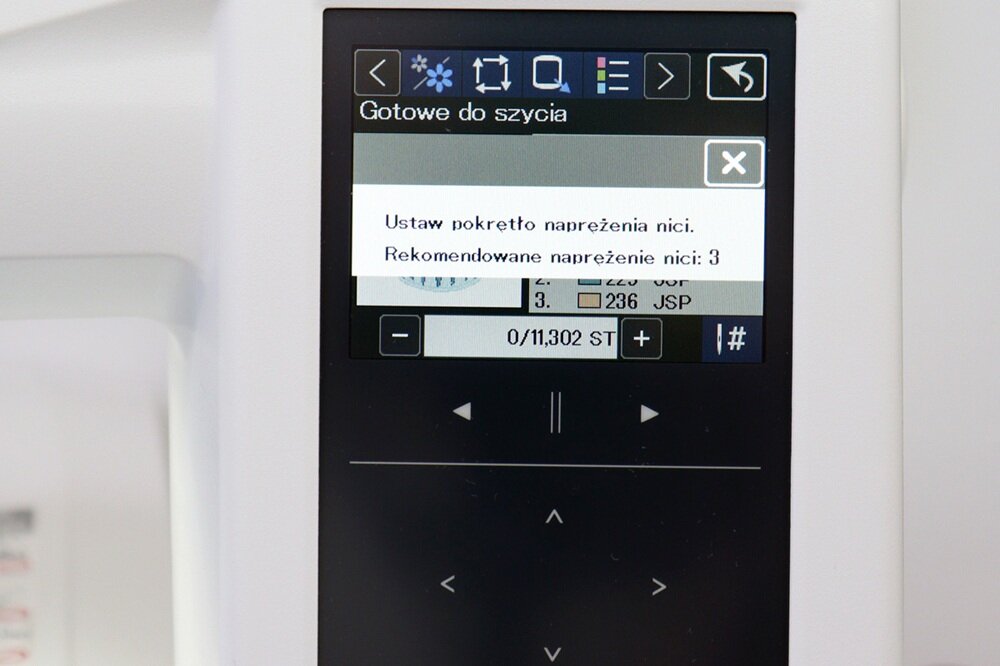 Ekran urządzenia z wyświetlonym komunikatem: \'Gotowe do szycia\'. Poniżej widoczny jest tekst: \'Ustaw pokrętło naprężenia nici. Rekomendowane naprężenie nici: 3\'.