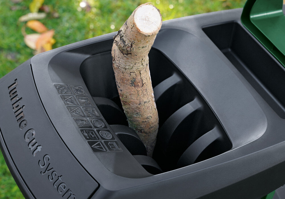 Rozdrabniacz do gałęzi BOSCH AXT 25 TC elektryczny 2500 W sekator + rękawice ogród trawnik zbliżenie na lej w leju umieszczona gałąź niski poziom hałasu (89 dB) praca jest bardziej komfortowa swobodne korzystanie z urządzenia wygoda i elastyczność w planowaniu prac ogrodowych