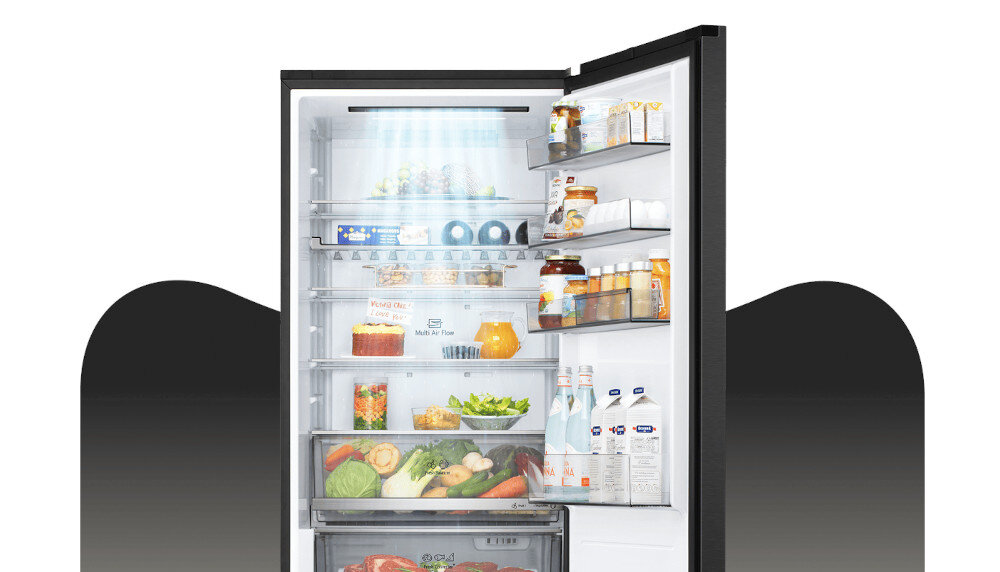 LODÓWKA LG GBBW322CEV Grafika przedstawia otwartą lodówkę LG z górną chłodziarką, wypełnioną jedzeniem rozmieszczonym na półkach, w szufladach i na balkonikach drzwi. Jasne oświetlenie LED w górnej części komory równomiernie rozjaśnia wnętrze, eksponując świeże warzywa, owoce, napoje oraz produkty w opakowaniach kartonowych i słoikach DoorCooling+ LG szybkie chłodzenie równomierne chłodzenie chłodzenie drzwi świeżość żywności chłodne napoje technologia LG lepsza cyrkulacja powietrza dłuższa świeżość