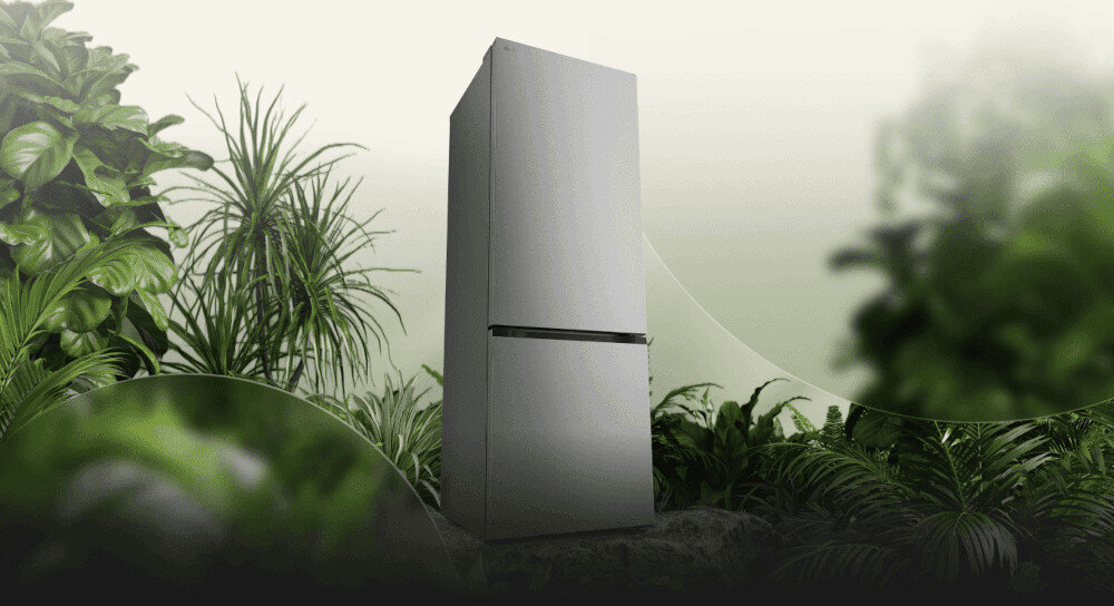LODÓWKA LG GBBSJ2CCPY Grafika przedstawia smukłą, ciemnoszarą lodówkę LG ustawioną pośród bujnej, zielonej roślinności na tle jasnego, rozmytego nieba. Kompozycja podkreśla ekologiczny charakter urządzenia, kojarząc je z naturą i energooszczędnością energooszczędna efektywma praca klasa C