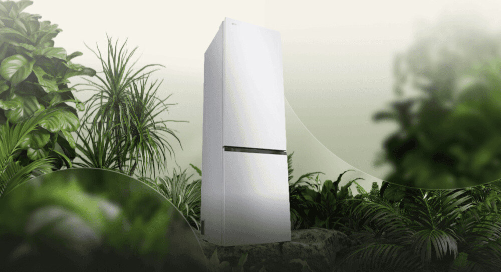 LODÓWKA LG GBBSJ20ESW Grafika przedstawia smukłą, ciemnoszarą lodówkę LG ustawioną pośród bujnej, zielonej roślinności na tle jasnego, rozmytego nieba. Kompozycja podkreśla ekologiczny charakter urządzenia, kojarząc je z naturą i energooszczędnością energooszczędna efektywma praca klasa E