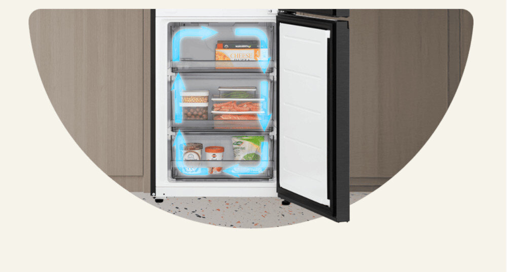 Otwarta lodówka z trzema szufladami, w których znajdują się różne produkty spożywcze. Wewnątrz widoczne są niebieskie strzałki symbolizujące przepływ powietrza No Frost.