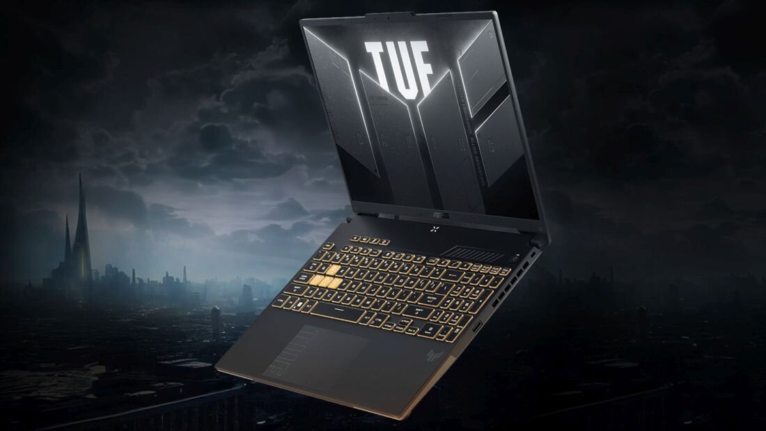 ASUS TUF Gaming F16 na ciemnym tle miejskim z logo TUF i podświetloną klawiaturą RGB, prezentującym system audio Dolby Atmos z wirtualnym dźwiękiem przestrzennym 5.1.2 dla immersyjnego doznania dźwiękowego w grach AAA z precyzyjną lokalizacją dźwięku - Dolby Atmos i Hi-Res Audio 