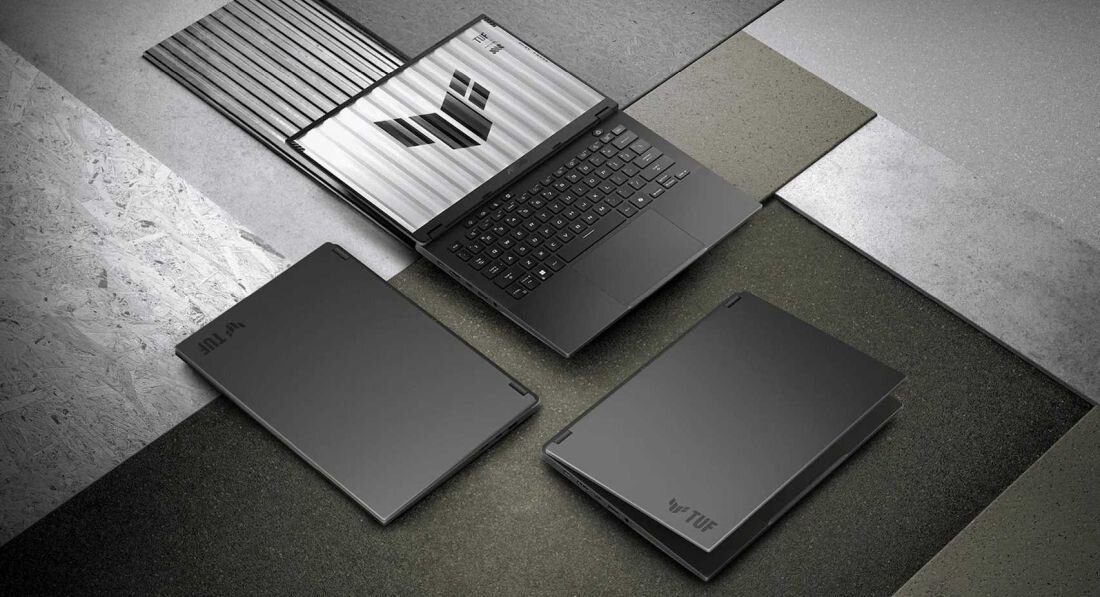 Kilka laptopów ASUS TUF Gaming leży na betonowym tle, pokazując solidną obudowę do mobilnego gamingu – AMD Ryzen z RTX serii 50 matrycą IPS 2K 165 Hz w smukłej obudowie 14 cali dla graczy i twórców