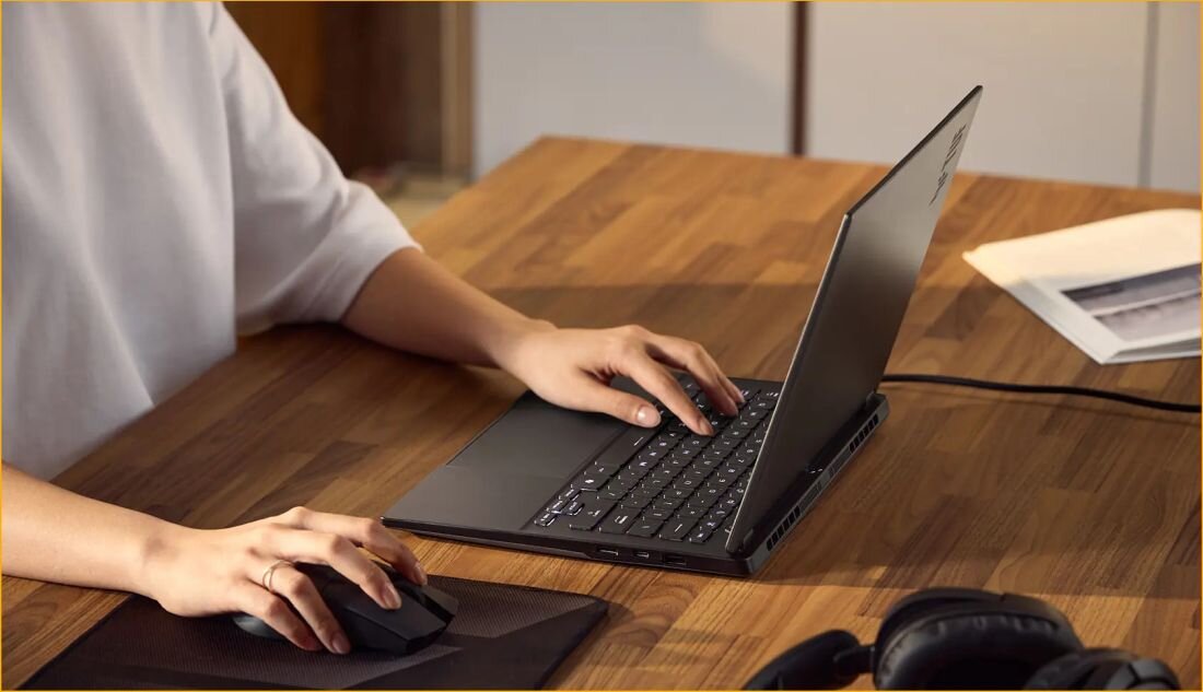 Osoba pracuje przy laptopie ASUS TUF Gaming na biurku, wykorzystując pamięć LPDDR5X do płynnej pracy – LPDDR5X 7500 MHz dual channel do gry streamingu i montażu 4K bez sięgania po pamięć wirtualną