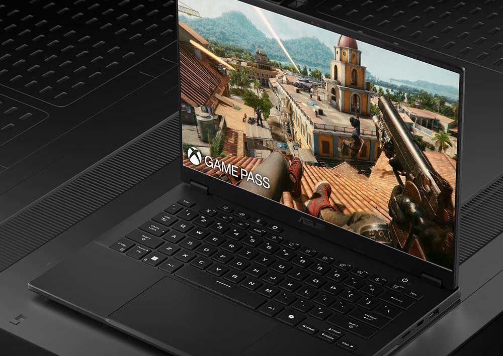 Laptop ASUS TUF Gaming pracuje na biurku, ilustrując długi czas działania na baterii podczas codziennej pracy – bateria 73 Wh z ładowaniem do 50% w 30 minut przez USB-C Power Delivery z powerbanku lub ładowarki telefonu