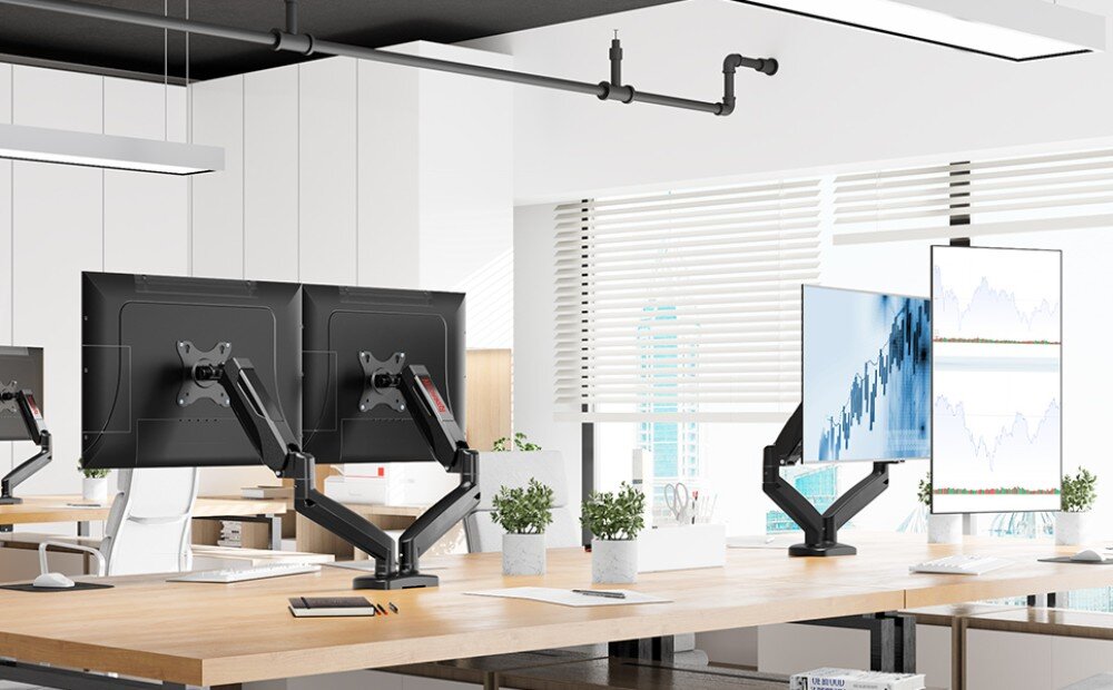 Uchwyt do monitora REDRAGON GMK915 Jasne pomieszczenie biurowe z rzędami biurek, na których zamontowano podwójne uchwyty z monitorami ustawionymi w różnych konfiguracjach, w tym jeden w pionie i jeden w poziomie