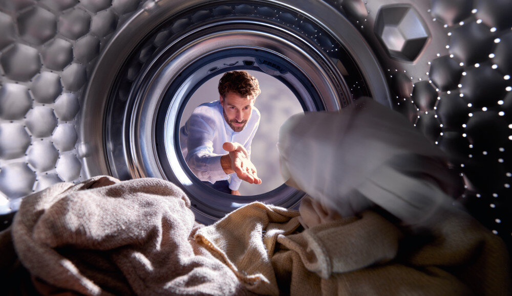 PRALKA MIELE WQ 1000 WPS zdjęcie lifestyle bęben mężczyzna dokładanie wrzucanie ubrań załadunek wnętrze AddLoad dodawanie zapomnianego prania automatycznie kontynuowany