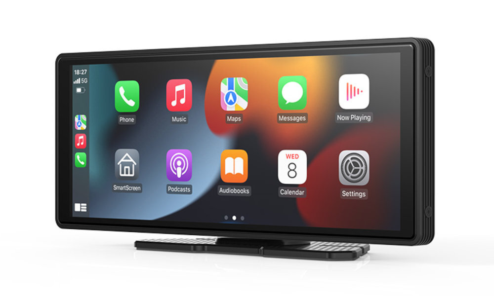 Na obrazie widoczny jest ekran z interfejsem CarPlay, na którym znajdują się ikony aplikacji takich jak Phone, Music, Maps, Messages, Now Playing, SmartScreen, Podcasts, Audiobooks, Calendar i Settings. W lewym górnym rogu ekranu widoczna jest godzina 18:27 oraz ikona 5G.
