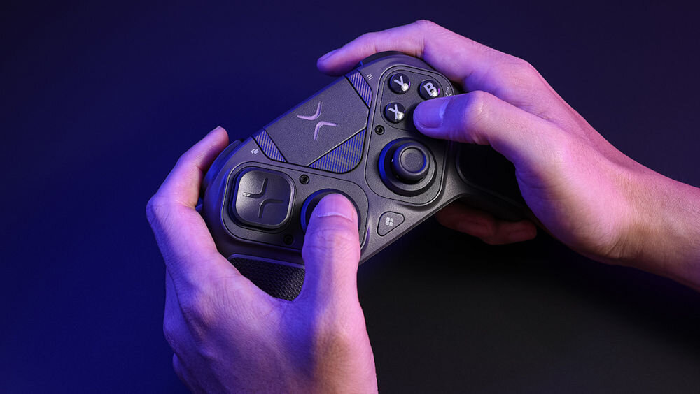 Kontroler TURTLE BEACH Victrix Pro BFG Reloaded Czarny Dłonie gracza trzymające kontroler Victrix podczas rozgrywki w ciemnym pomieszczeniu z niebiesko-różowym światłem ergonomiczny skuteczny kontroler