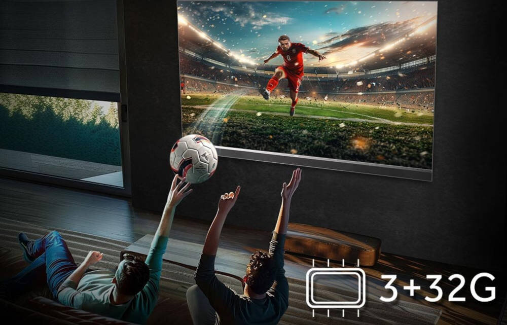 Telewizor HAIER H65M95EUX 3 GB RAM 32 GB pamięci płynne działanie, osoby siedzace na kanapie łapiące piłkę, telewizor zawieszony na ścianie