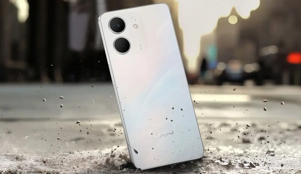 Smartfon z dwoma dużymi obiektywami aparatu na tylnej obudowie, ustawiony pod kątem na tle miejskiej ulicy. Na obudowie widoczne jest logo \'oppo\'.