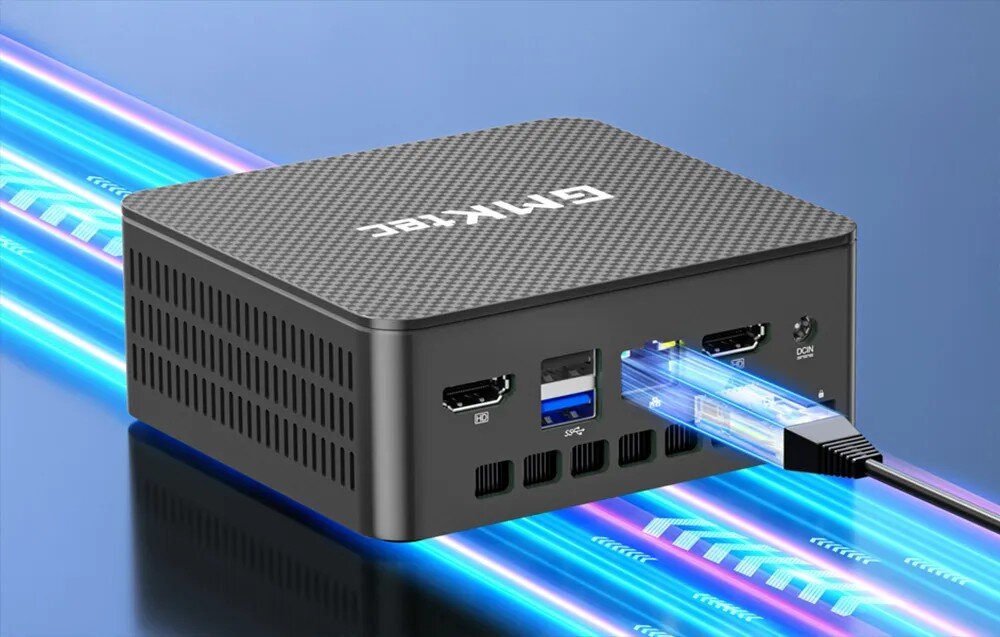 Komputer GMKTEC G3S Widok na tył małego komputera z podłączonym kablem sieciowym oraz widocznymi portami HDMI i USB na tle niebieskich smug światła