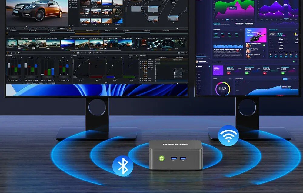 Komputer GMKTEC G3S Widok na dwa monitory wyświetlające kolorowe wykresy i interfejsy programów, przed którymi stoi mały komputer z ikonami łączności bezprzewodowej