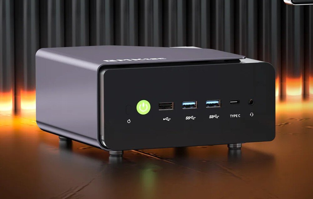 Komputer GMKTEC NucBox K12 Przedni panel czarnego mini komputera z widocznym zielonym przyciskiem zasilania, portami USB oraz złączem audio