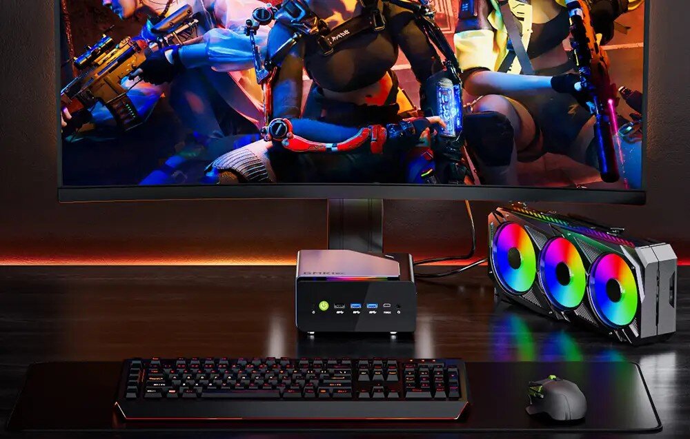 Komputer GMKTEC NucBox K12 Wieloelementowe stanowisko pracy z mini komputerem, monitorem, laptopem na stojaku i tabletem na tle ceglanej ściany