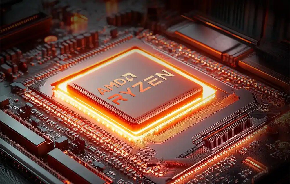 Komputer GMKTEC NucBox K12 Zbliżenie na procesor z logo 'AMD RYZEN' otoczony pomarańczową poświatą podkreślającą wydajność układu