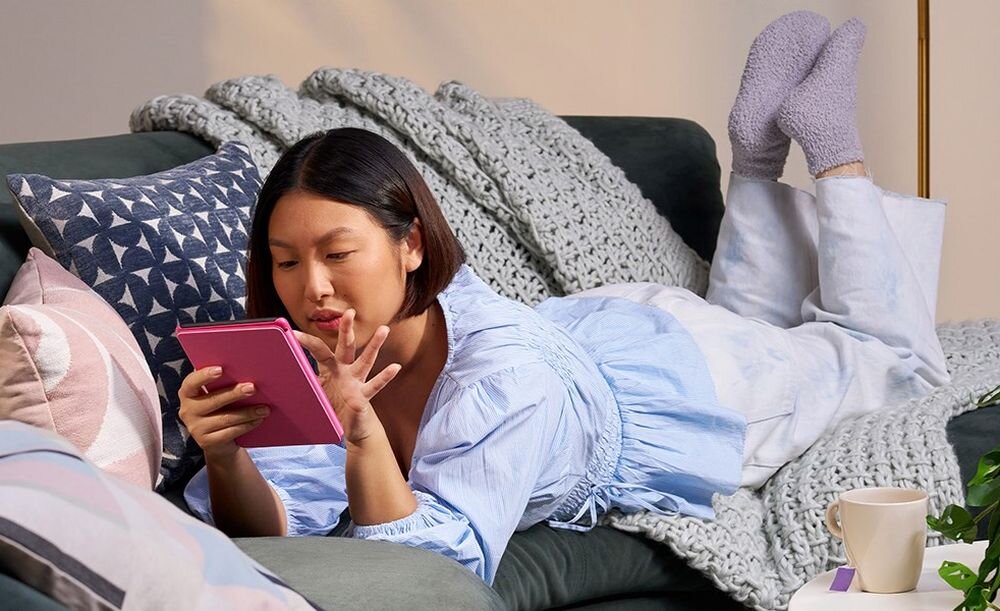 Czytnik e-booków AMAZON Kindle 7 kobieta lezy na kanapie z czytnikiem w rece - srodowisko - jakosc technologia funkcjonalnosc styl ekologia recykling