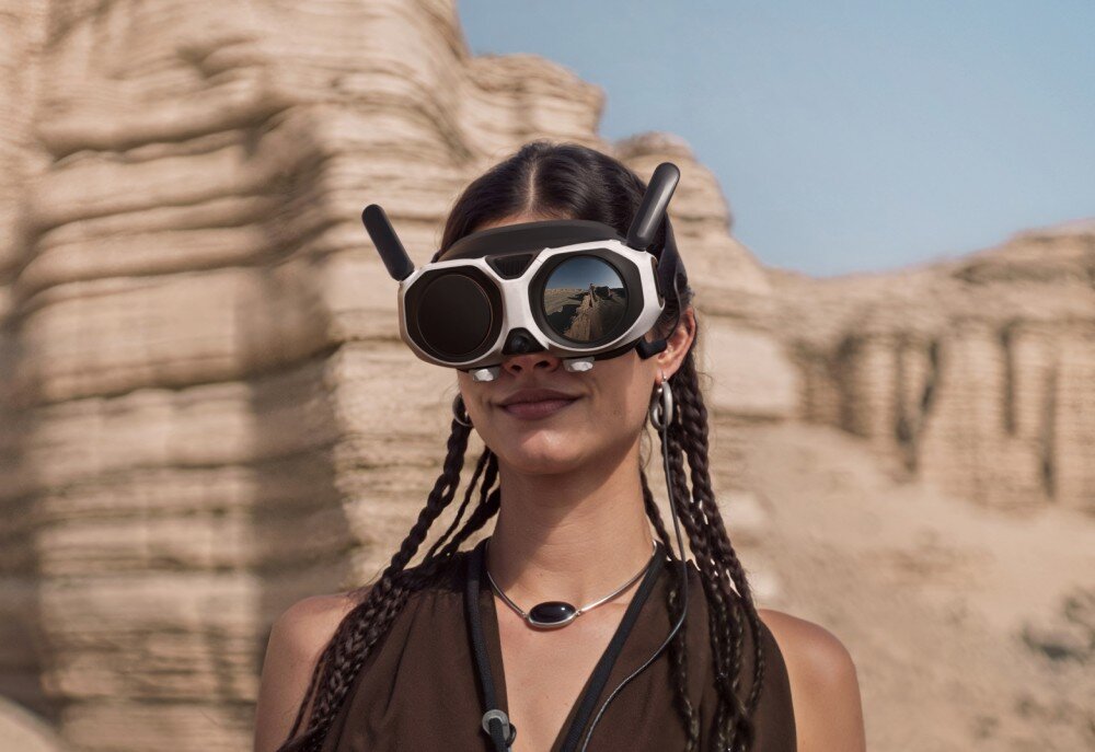 Dron ANTIGRAVITY A1 Kobieta w goglach z widocznym odbiciem pustynnego krajobrazu w przedniej osłonie, cechy, zalety, zastosowanie