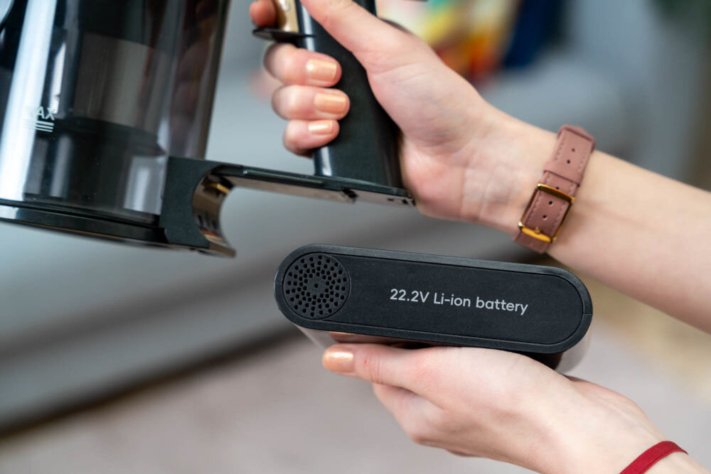 Osoba trzyma odkurzacz i wyjmowaną baterię z napisem \'22.2V Li-ion battery\'.