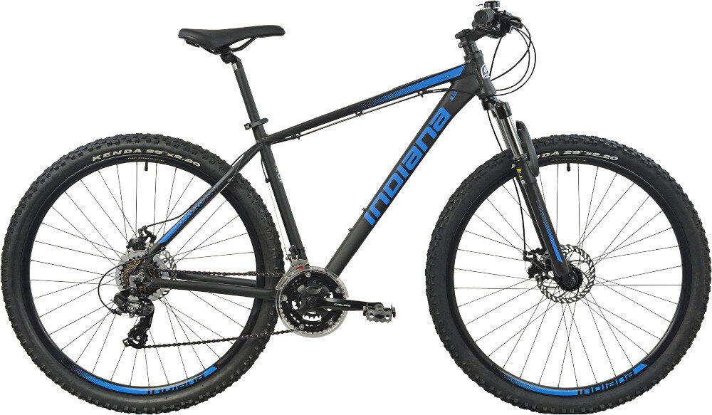 Rower górski MTB INDIANA X-Pulser 1.9 M21 29 cali męski Czarno-niebieski droga gruntowa osoba w kasku jedzie po drodze gruntowej w tle łąka niebieskie niebo pasja jazda na rowerze środek transportu