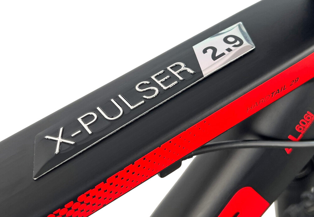 Zbliżenie na ramę roweru z widocznym napisem \'X-PULSER 2.9\' oraz fragmentem czerwonego wzoru. Na ramie znajduje się również napis \'HARDTAIL 29\'.