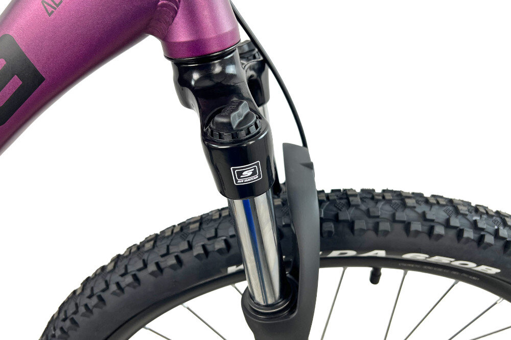 Rower górski MTB INDIANA X-Pulser 3.7 D17 27.5 cala damski Fioletowy zbliżenie na amortyzator widok z góry i z boku białe tło rower typu hardtail przedni amortyzator marki SR Suntour typu XCE-28 DS 27.5 cali skutecznie tłumi drgania i wstrząsy płynna i stabilna jazda amortyzator poprawia przyczepność kół kontrola nad rowerem wyższy poziom bezpieczeństwa i komfortu jazdy