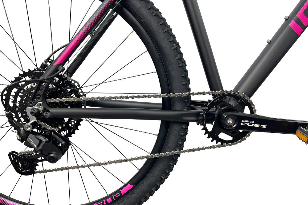 Rower górski MTB INDIANA X-Pulser 3.7 D17 27.5 cala damski Czarno-fuksjowy zbliżenie na łańcuch i napęd białe tło łańcuch KMC Eglide 9V Cues dopasowany do napędów 9-rzędowych odpowiednia konstrukcja ogniw wspiera płynną współpracę z elementami układu napędowego zmiana przełożeń może odbywać się sprawnie i z zachowaniem odpowiedniej kultury pracy