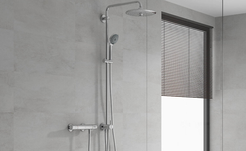 SYSTEM PRYSZNICOWY GROHE VITALIO JOY 260 LONGLIFE MASSAGE 27357002 CHROM Na zdjęciu widoczny jest zestaw prysznicowy z deszczownicą i słuchawką prysznicową, zamontowany na jasnej, minimalistycznej ścianie. Chromowane wykończenie i prosta forma podkreślają elegancki, współczesny charakter łazienki