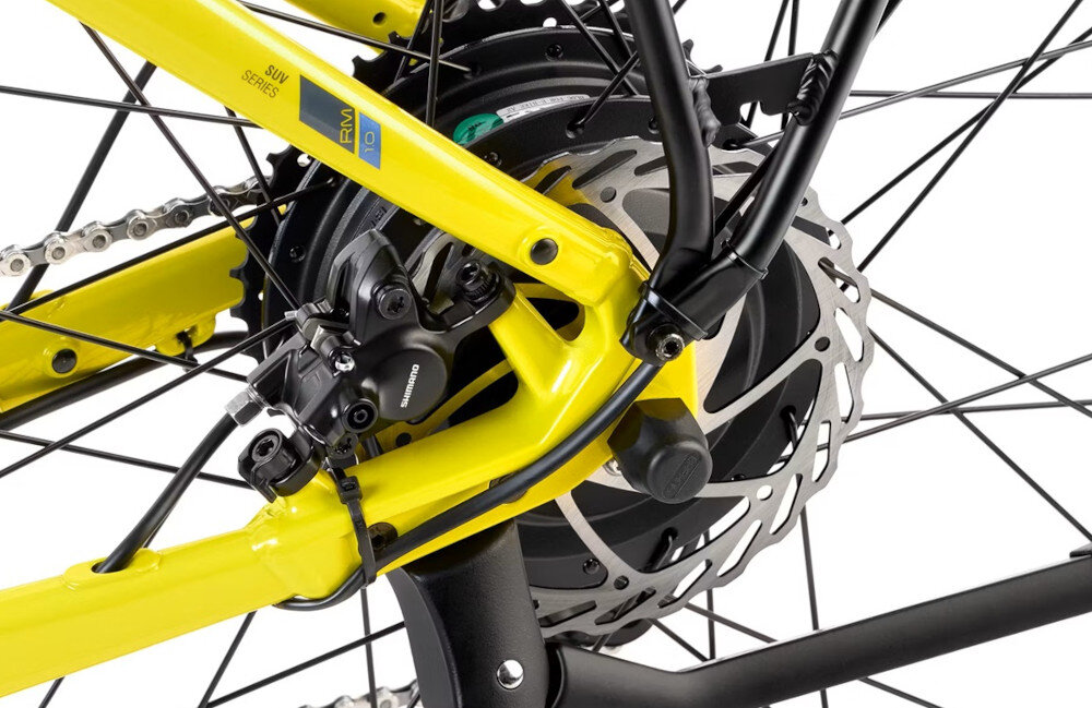 Zbliżenie na tylne koło roweru elektrycznego z limonkową ramą i widocznym mechanizmem hamulcowym. Na ramie znajduje się napis \'SUV SERIES\' oraz \'RM 1.0\'.