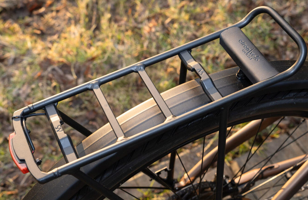 Rower elektryczny ROMET E-Modeco URB 2.0 U17 28 cali Brązowo-czarny zbliżenie na bagażnik trawnik bagażnik składana stopka w centralnym punkcie ciężkości