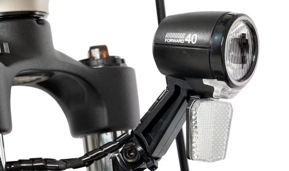 Rower elektryczny ROMET E-Modeco URB 1.0 U19 28 cali Szampańsko-czarny zbliżenie na przednią lampę bezpieczeństwo przednie i tylne oświetlenie dobra widoczność i bezpieczeństwo na drodze światła zasilane są bezpośrednio z baterii wymagane przez prawo drogowe