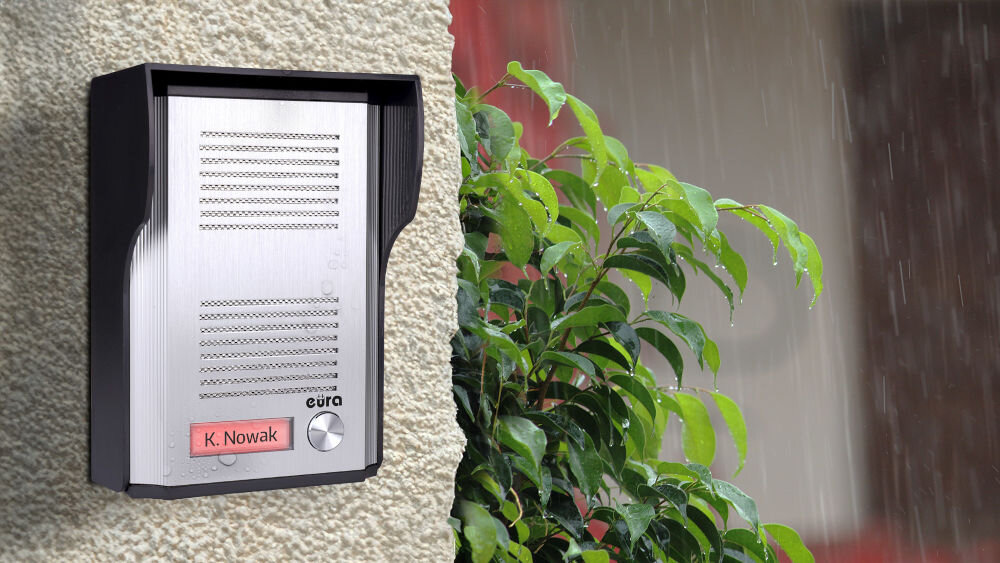 Zestaw domofonowy EURA Remoto ADP-41A3 Biały, obudowa, trwałość, montaż, daszek ,turdne warunki, brelok, Domofon zamontowany ścianie zewnętrznej budynku podczas opadów deszczu