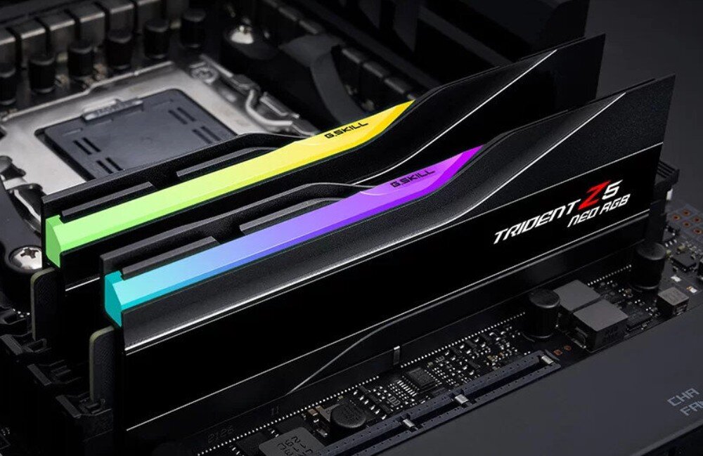 Komputer MAD DOG GeForce RTX5070Ti DLSS 4 Reflex Edition 2 DEEPCOOL-A20WR32WP Zbliżenie na dwa moduły pamięci RAM z serii Trident Z5 Neo RGB zamontowane w płycie głównej, z podświetleniem w kolorach żółtym, zielonym, fioletowym i niebieskim, pamięć RAM, taktowanie, opóźnienia, profile EXPO